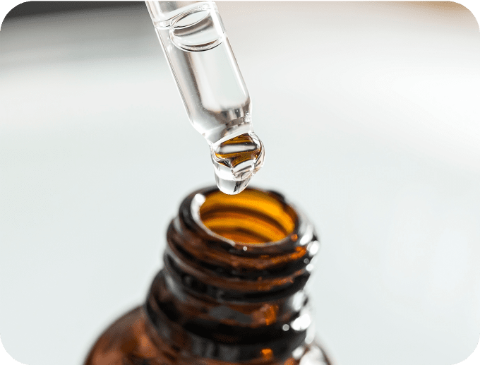 容器から美容液を数滴取り出している画像